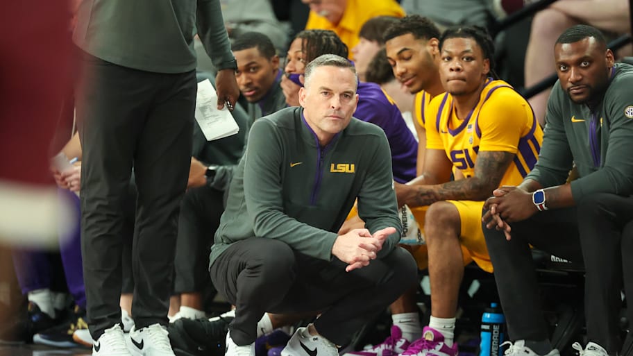 LSU basketball coach Matt McMahon crouches on the sideline.