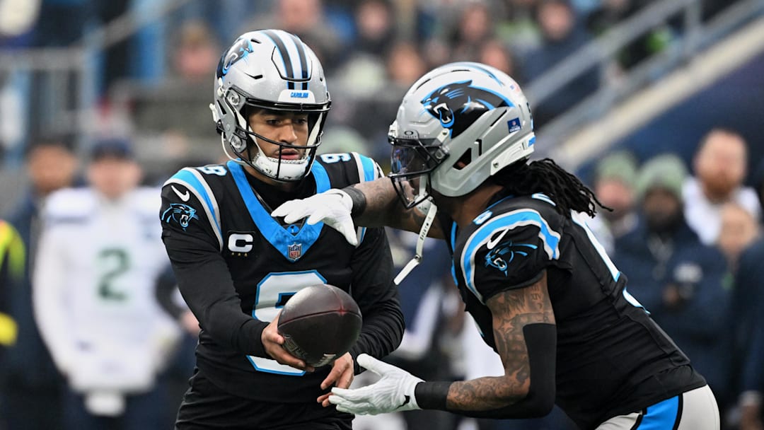 Dec 28, 2025; Charlotte, North Carolina, USA; Carolina Panthers quarterback Bryce Young (9) hands the ball to running back Rico Dowdle (5) against the Seattle Seahawks during the first quarter at Bank of America Stadium. Mandatory Credit: Bob Donnan-Imagn Images