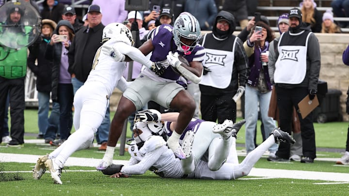 Nov 29, 2025; Manhattan, Kansas, USA; Kansas State Wildcats running back Joe Jackson (4) is tackled by Colorado Buffaloes cornerback Preston Hodge (4) during the fourth quarter at Bill Snyder Family Football Stadium. 