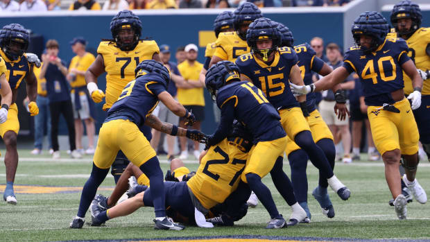 The West Virginia University defense swarms freshman running back Clay Ash during the Gold-Blue Spring Game.
