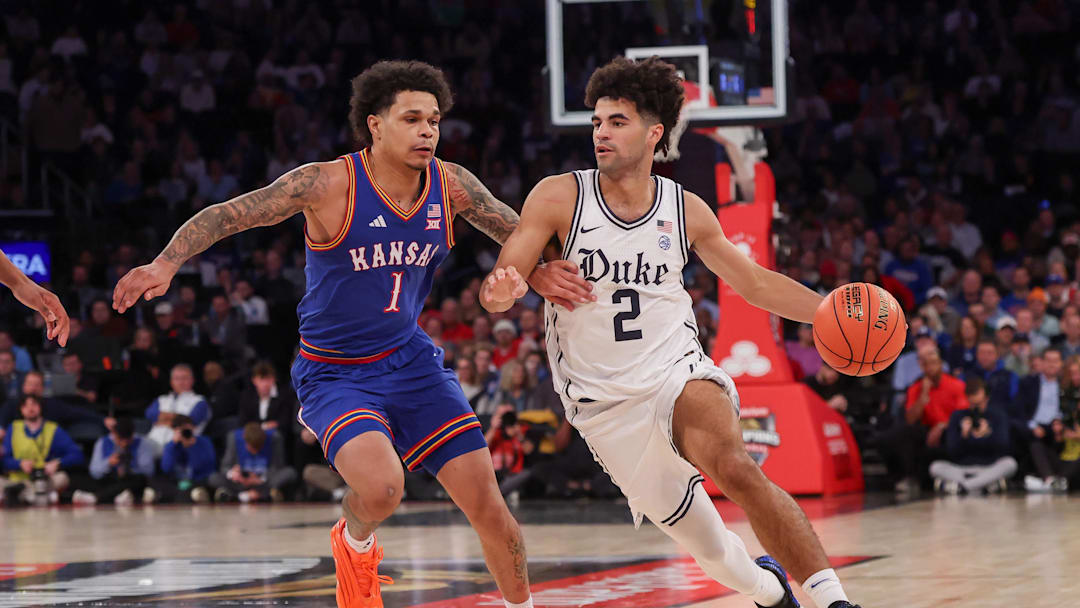 Nov 18, 2025; New York, New York, USA; Duke basketball guard Cayden Boozer (2) dribbles as Kansas Jayhawks guard Jayden Dawson (1) defends during the second half at Madison Square Garden. 