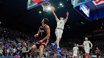 Jan 25, 2025; Lawrence, Kansas, USA; Kansas Jayhawks guard Zeke Mayo (5) shoots a layup as Houston Cougars guard Milos Uzan (7) looks on during the second half at Allen Fieldhouse. Mandatory Credit: Denny Medley-Imagn Images