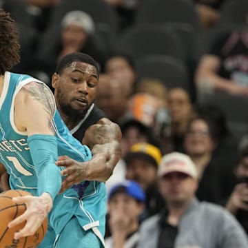 Mar 14, 2025; San Antonio, Texas, USA; San Antonio Spurs guard Malaki Branham (22) reaches in for the ball while defending Charlotte Hornets guard LaMelo Ball (1) during the second half at Frost Bank Center. Mandatory Credit: Scott Wachter-Imagn Images