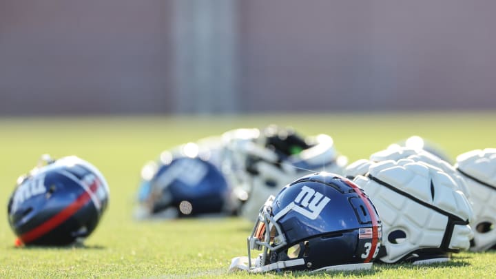 Aug 1, 2023; East Rutherford, NJ, USA; New York Giants helmets rest on the grass field during training camp at the Quest Diagnostics Training Facility.  