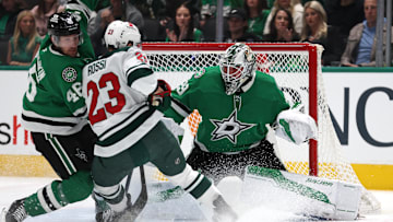 Dec 27, 2024; Dallas, Texas, USA; Dallas Stars defenseman Ilya Lyubushkin (46) defends Minnesota Wild center Marco Rossi (23) as goaltender Jake Oettinger (29) protects the goal in the first period at American Airlines Center. Mandatory Credit: Tim Heitman-Imagn Images