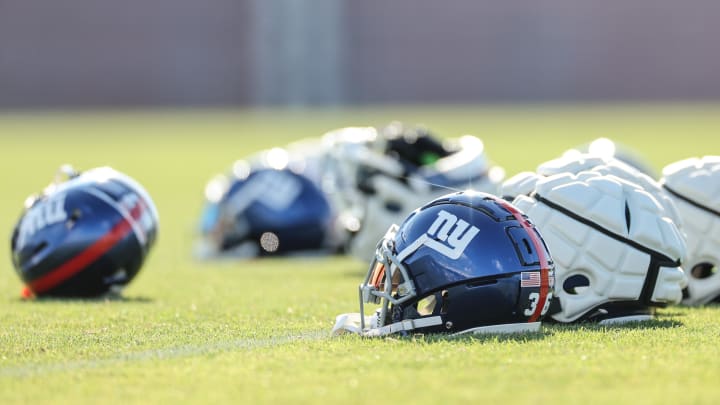 Aug 1, 2023; East Rutherford, NJ, USA; New York Giants helmets rest on the grass field during training camp at the Quest Diagnostics Training Facility.   