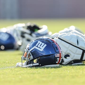 New York Giants helmets rest on the grass field at the Quest Diagnostics Training Facility.   