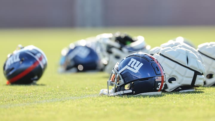 Aug 1, 2023; East Rutherford, NJ, USA; New York Giants helmets rest on the grass field during training camp at the Quest Diagnostics Training Facility.   