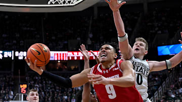 Mar 2, 2025; East Lansing, Michigan, USA;  Wisconsin Badgers guard John Tonje (9) slashes past Michigan State Spartans forward Jaxon Kohler (0) during the first half at Jack Breslin Student Events Center. Mandatory Credit: Dale Young-Imagn Images