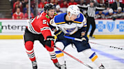 Sep 28, 2023; Chicago, Illinois, USA; Chicago Blackhawks defenseman Kevin Korchinski (55) defends against St. Louis Blues forward Zachary Bolduc (76) in the second period at United Center. Mandatory Credit: Jamie Sabau-Imagn Images