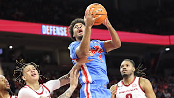 Jan 8, 2025; Fayetteville, Arkansas, USA; Ole Miss Rebels forward Jaemyn Brakefield (4) shoots in the first half as  Arkansas Razorbacks forwards Trevon Brazile (4) and Jonas Aidoo (9) defends at Bud Walton Arena. Mandatory Credit: Nelson Chenault-Imagn Images