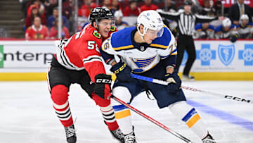 Sep 28, 2023; Chicago, Illinois, USA; Chicago Blackhawks defenseman Kevin Korchinski (55) defends against St. Louis Blues forward Zachary Bolduc (76) in the second period at United Center. Mandatory Credit: Jamie Sabau-Imagn Images