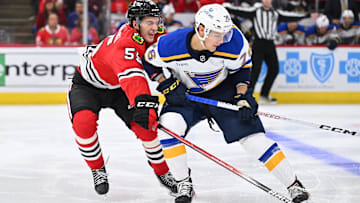 Sep 28, 2023; Chicago, Illinois, USA; Chicago Blackhawks defenseman Kevin Korchinski (55) defends against St. Louis Blues forward Zachary Bolduc (76) in the second period at United Center. Mandatory Credit: Jamie Sabau-Imagn Images