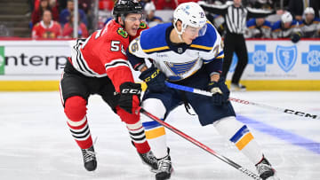 Sep 28, 2023; Chicago, Illinois, USA; Chicago Blackhawks defenseman Kevin Korchinski (55) defends against St. Louis Blues forward Zachary Bolduc (76) in the second period at United Center. Mandatory Credit: Jamie Sabau-USA TODAY Sports