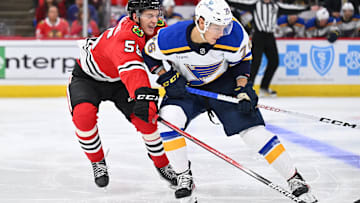 Sep 28, 2023; Chicago, Illinois, USA; Chicago Blackhawks defenseman Kevin Korchinski (55) defends against St. Louis Blues forward Zachary Bolduc (76) in the second period at United Center. Mandatory Credit: Jamie Sabau-Imagn Images