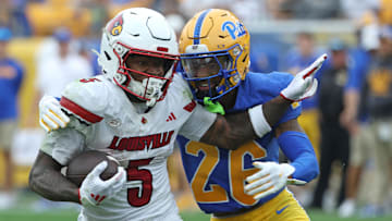 Sep 27, 2025; Pittsburgh, Pennsylvania, USA;  Louisville Cardinals wide receiver Caullin Lacy (5) runs after a catch against Pittsburgh Panthers defensive back Allen Bryant (26) during the fourth quarter at Acrisure Stadium. Mandatory Credit: Charles LeClaire-Imagn Images