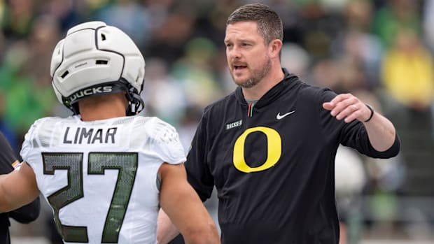 Oregon coach Dan Lanning greets Fighting Ducks running back Jayden Limar.