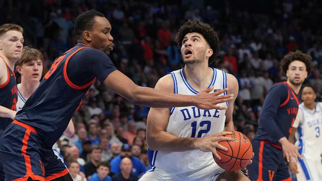 Mar 14, 2026; Charlotte, NC, USA; Duke Blue Devils forward Cameron Boozer (12) with the ball as Virginia Cavaliers center Ugonna Onyenso (33) defends in the second half during the men's ACC Conference Tournament Championship at Spectrum Center.