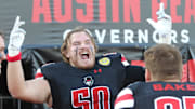 Austin Peay offensive lineman Brennan Smith (50) jokingly gestures to teammates, including Jack Baker (87), on the sideline in the first half against Murray State during their game in 2022.