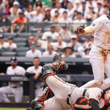 Jun 22, 2025; Bronx, New York, USA; New York Yankees second baseman Jazz Chisholm Jr. (13) collides with Baltimore Orioles catcher Maverick Handley (98) at home plate during the second inning at Yankee Stadium. Mandatory Credit: Vincent Carchietta-Imagn Images