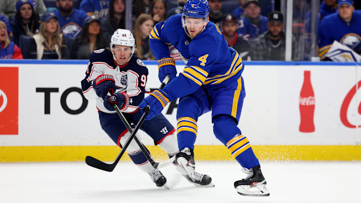 Oct 28, 2025; Buffalo, New York, USA;  Columbus Blue Jackets center Kent Johnson (91) and Buffalo Sabres defenseman Bowen Byram (4) go after a loose puck during the first period at KeyBank Center. Mandatory Credit: Timothy T. Ludwig-Imagn Images