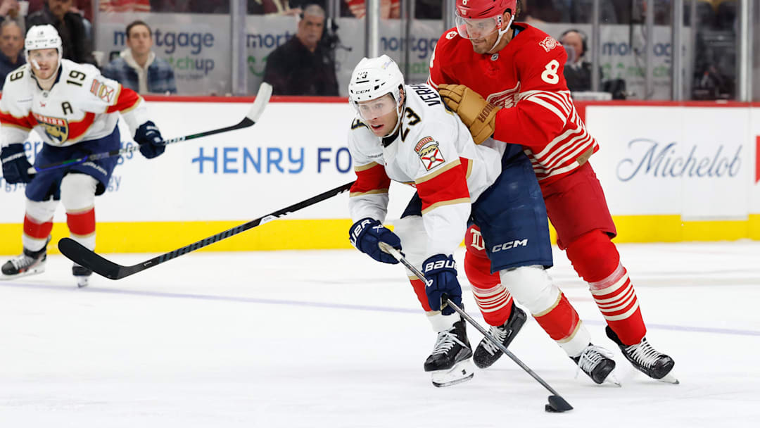 Mar 6, 2026; Detroit, Michigan, USA;  Florida Panthers center Carter Verhaeghe (23) skates with the puck defended by Detroit Red Wings defenseman Ben Chiarot (8) in the third period at Little Caesars Arena. Mandatory Credit: Rick Osentoski-Imagn Images