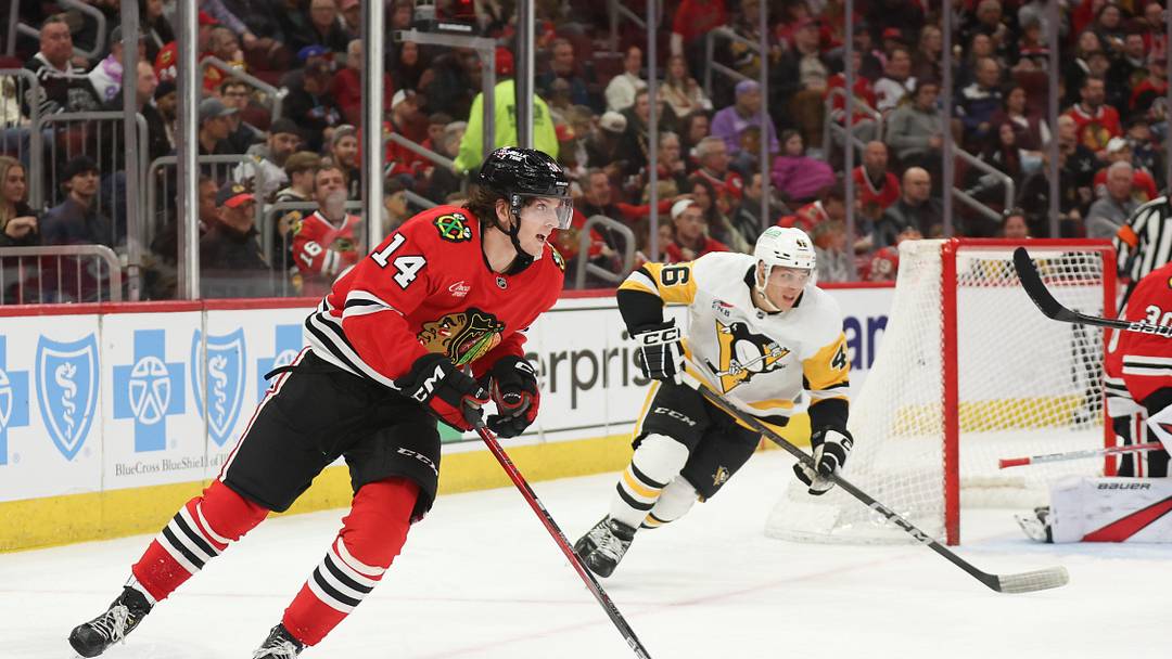 Apr 6, 2025; Chicago, Illinois, USA; Chicago Blackhawks defenseman Kevin Korchinski (14) skates with the puck against the Pittsburgh Penguins during the second period at United Center. Mandatory Credit: Talia Sprague-Imagn Images