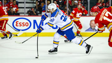 Oct 11, 2025; Calgary, Alberta, CAN; St. Louis Blues center Pius Suter (22) shoots the puck against the Calgary Flames during the third period at Scotiabank Saddledome. Mandatory Credit: Sergei Belski-Imagn Images