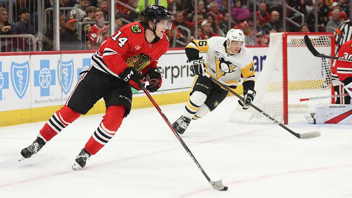 Apr 6, 2025; Chicago, Illinois, USA; Chicago Blackhawks defenseman Kevin Korchinski (14) skates with the puck against the Pittsburgh Penguins during the second period at United Center. Mandatory Credit: Talia Sprague-Imagn Images