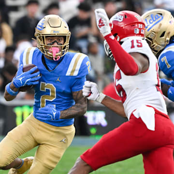 Nov 30, 2024; Pasadena, California, USA; UCLA Bruins wide receiver Titus Mokiao-Atimalala (2)  tries to run past Fresno State Bulldogs defensive back Julian Neal (15) during the fourth quarter at Rose Bowl. Mandatory Credit: Robert Hanashiro-Imagn Images