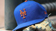 Jul 13, 2022; Atlanta, Georgia, USA; A detailed view of a New York Mets hat and glove in the dugout against the Atlanta Braves in the eighth inning at Truist Park. 