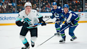 Sep 26, 2025; Vancouver, British Columbia, CAN;  Seattle Kraken forward Berkly Catton (77) and Vancouver Canucks defenseman Guillaume Brisebois (55) look for the loose puck in the second period at Rogers Arena. Mandatory Credit: Bob Frid-Imagn Images