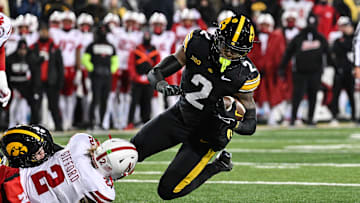 Nov 29, 2024; Iowa City, Iowa, USA; Iowa Hawkeyes running back Kaleb Johnson (2) runs the ball as Nebraska Cornhuskers defensive back Isaac Gifford (2) makes the tackle during the third quarter at Kinnick Stadium. Mandatory Credit: Jeffrey Becker-Imagn Images