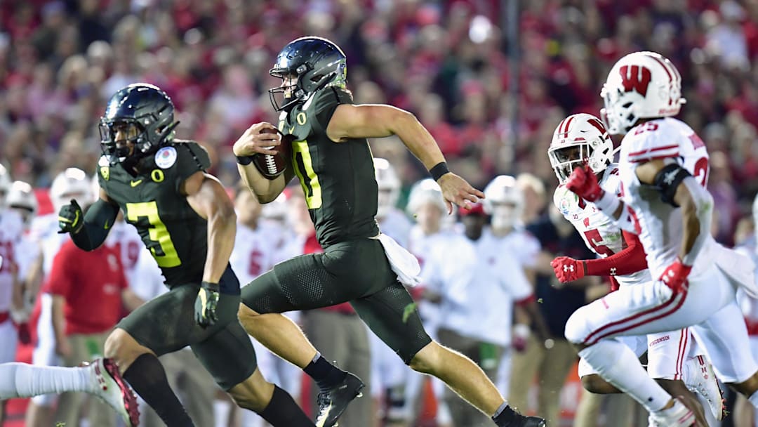 Jan 1, 2020; Pasadena, California, USA; Oregon Ducks quarterback Justin Herbert (10) runs for a touchdown against the Wisconsin Badgers in the third quarter during the 106th Rose Bowl game at Rose Bowl Stadium. Mandatory Credit: Gary A. Vasquez-Imagn Images