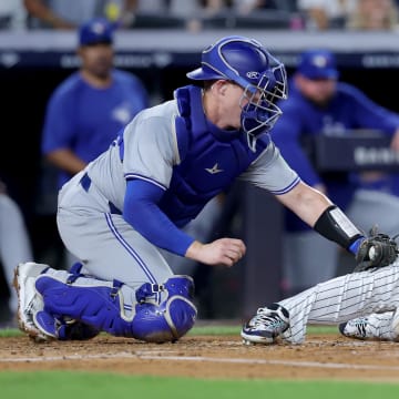 Aug 2, 2024; Bronx, New York, USA; Toronto Blue Jays catcher Brian Serven (15) tags out New York Yankees second baseman Gleyber Torres (25) trying to score on a base hit by Yankees shortstop Anthony Volpe (not pictured) during the second inning at Yankee Stadium. 