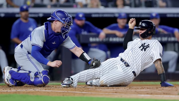 Aug 2, 2024; Bronx, New York, USA; Toronto Blue Jays catcher Brian Serven (15) tags out New York Yankees second baseman Gleyber Torres (25) trying to score on a base hit by Yankees shortstop Anthony Volpe (not pictured) during the second inning at Yankee Stadium. 