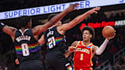 Dec 5, 2025; Atlanta, Georgia, USA; Atlanta Hawks forward Jalen Johnson (1) passes around Denver Nuggets guard Peyton Watson (8) and forward Spencer Jones (21) in the second quarter at State Farm Arena. Mandatory Credit: Brett Davis-Imagn Images
