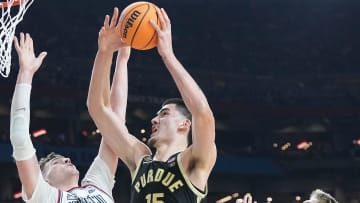 Connecticut Huskies center Donovan Clingan (32) and Connecticut Huskies guard Cam Spencer (12) defend the shot of Purdue Boilermakers center Zach Edey (15) during the NCAA Men’s Basketball Tournament Championship, Monday, April 8, 2024, at State Farm Stadium in Glendale, Ariz.