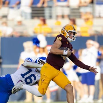 Nov 23, 2024; Tempe, Arizona, USA; Arizona State Sun Devils quarterback Sam Leavitt (10) against diving Brigham Young Cougars linebacker Isaiah Glasker (16) at Mountain America Stadium. Mandatory Credit: Mark J. Rebilas-Imagn Images
