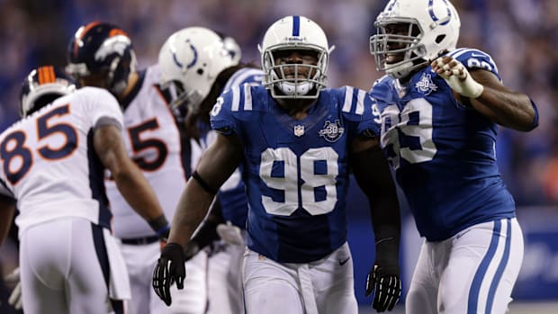 Former Colts defensive end Robert Mathis (blue jersey) celebrates after making a big play on the field.