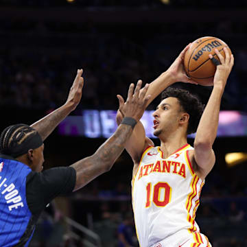 Apr 15, 2025; Orlando, Florida, USA; Atlanta Hawks forward Zaccharie Risacher (10) drives to the basket past Orlando Magic guard Kentavious Caldwell-Pope (3) in the first quarter at Kia Center. Mandatory Credit: Nathan Ray Seebeck-Imagn Images