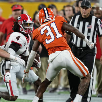 Sep 4, 2021; Charlotte, North Carolina, USA; Georgia Bulldogs running back James Cook (4) is chased by Clemson Tigers linebacker Baylon Spector (10) and cornerback Mario Goodrich (31) during the first quarter at Bank of America Stadium. Mandatory Credit: Jim Dedmon-USA TODAY Sports