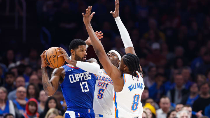 Dec 21, 2023; Oklahoma City, Oklahoma, USA; LA Clippers forward Paul George (13) is defended by Oklahoma City Thunder guard Luguentz Dort (5) and forward Jalen Williams (8) as he attempts to pass during the second quarter at Paycom Center. Mandatory Credit: Alonzo Adams-USA TODAY Sports