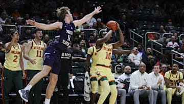 Dec 29, 2023; Coral Gables, Florida, USA; Miami Hurricanes guard Paul Djobet (10) shoots the basketball against North Florida Ospreys guard Oscar Berry (33) during the second half at Watsco Center. Mandatory Credit: Sam Navarro-Imagn Images