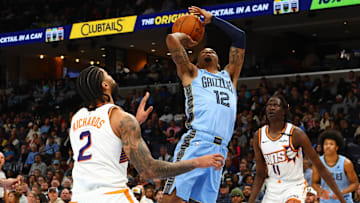 Feb 25, 2025; Memphis, Tennessee, USA; Memphis Grizzlies guard Ja Morant (12) shoots as Phoenix Suns center Nick Richards (2) defends during the second quarter at FedExForum. Mandatory Credit: Petre Thomas-Imagn Images