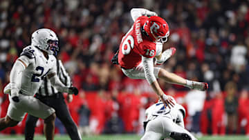 Nov 29, 2025; Piscataway, New Jersey, USA; Rutgers Scarlet Knights quarterback Athan Kaliakmanis (16) fights for yards as Penn State Nittany Lions cornerback Zion Tracy (7) tackles during the second half at SHI Stadium. Mandatory Credit: Vincent Carchietta-Imagn Images