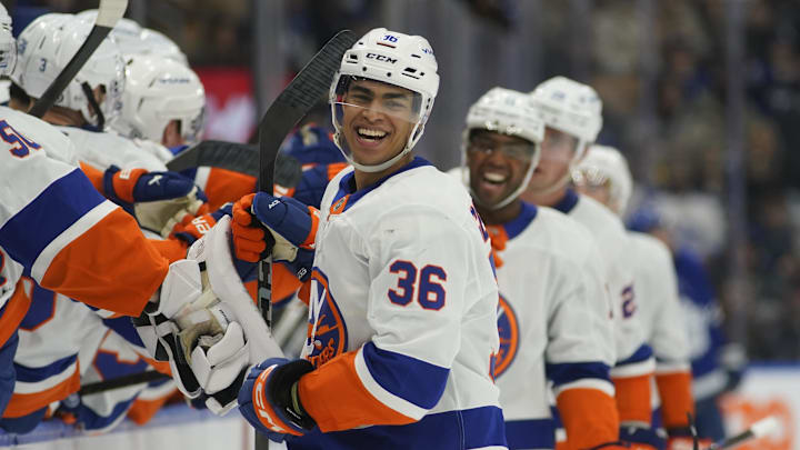 Dec 21, 2024; Toronto, Ontario, CAN; New York Islanders defenseman Isaiah George (36) gets congratulated at the bench after scoring his first goal of the season against the Toronto Maple Leafs during the third period at Scotiabank Arena. Mandatory Credit: John E. Sokolowski-Imagn Images