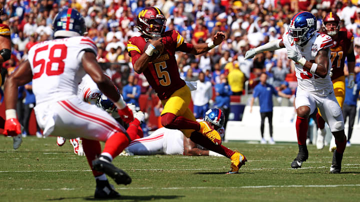 Sep 15, 2024; Landover, Maryland, USA; Washington Commanders quarterback Jayden Daniels (5) runs the ball against New York Giants safety Tyler Nubin (31) and linebacker Bobby Okereke (58) during the fourth quarter at Commanders Field.  