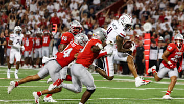 Aug 31, 2024; Tucson, Arizona, USA; Arizona Wildcats wide receiver Tetairoa McMillan (4) dodges tackle by New Mexico Lobos safety Christian Ellis (8) and New Mexico Lobos safety Noa Pola-Gates (4) during third quarter at Arizona Stadium. Mandatory Credit: Aryanna Frank-Imagn Images