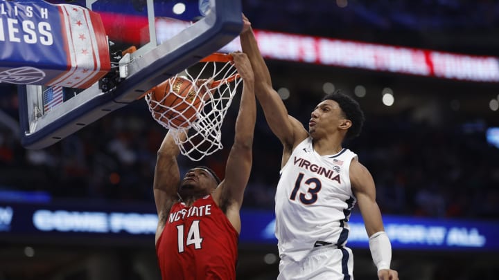 Mar 15, 2024; Washington, D.C., USA; North Carolina State Wolfpack guard Casey Morsell (14) dunks the ball as Virginia Cavaliers guard Ryan Dunn (13) defends in the second half at Capital One Arena. Mandatory Credit: Geoff Burke-USA TODAY Sports